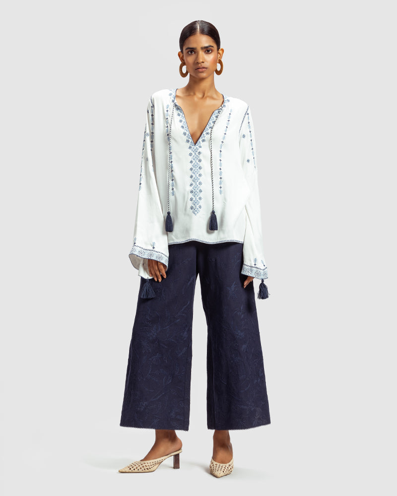 Blue on White Embroidered Satin Blend TopProduct DescriptionThis relaxed-fit top is adorned with Kolam-inspired motif embroidery, and also features tassels on the front-neck drawstring and sleeve hems.
FroWhite Embroidered Satin Blend Top