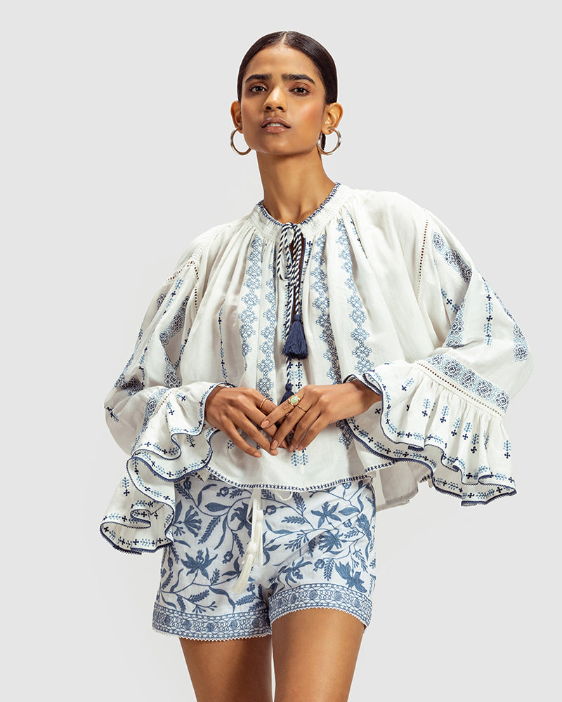 Blue on White Embroidered Linen Blend Boho TopProduct DescriptionThis linen blend boho top features an eclectic blend of blue-on-white lace and embroidery with Kolam-inspired motifs. Comes in an oversized relaxeTopsWhite Embroidered Linen Blend Boho Top