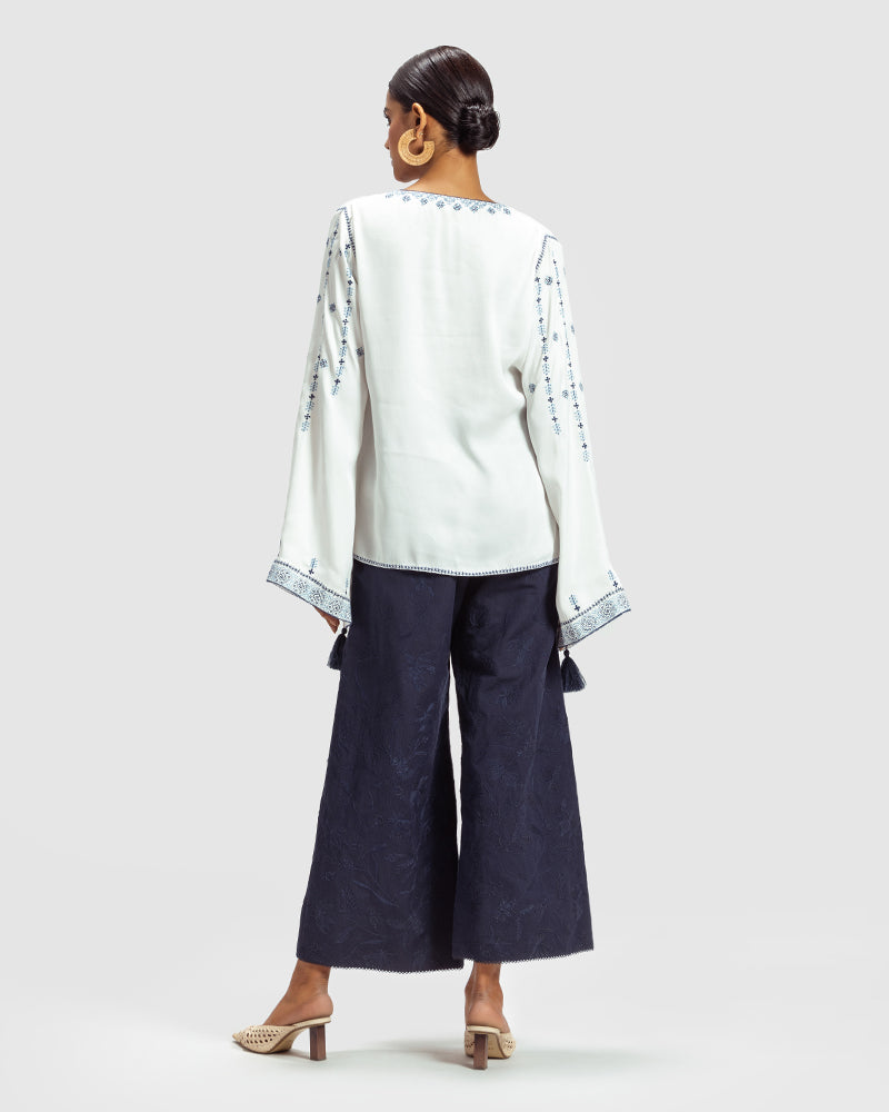 Blue on White Embroidered Satin Blend TopProduct DescriptionThis relaxed-fit top is adorned with Kolam-inspired motif embroidery, and also features tassels on the front-neck drawstring and sleeve hems.
FroWhite Embroidered Satin Blend Top
