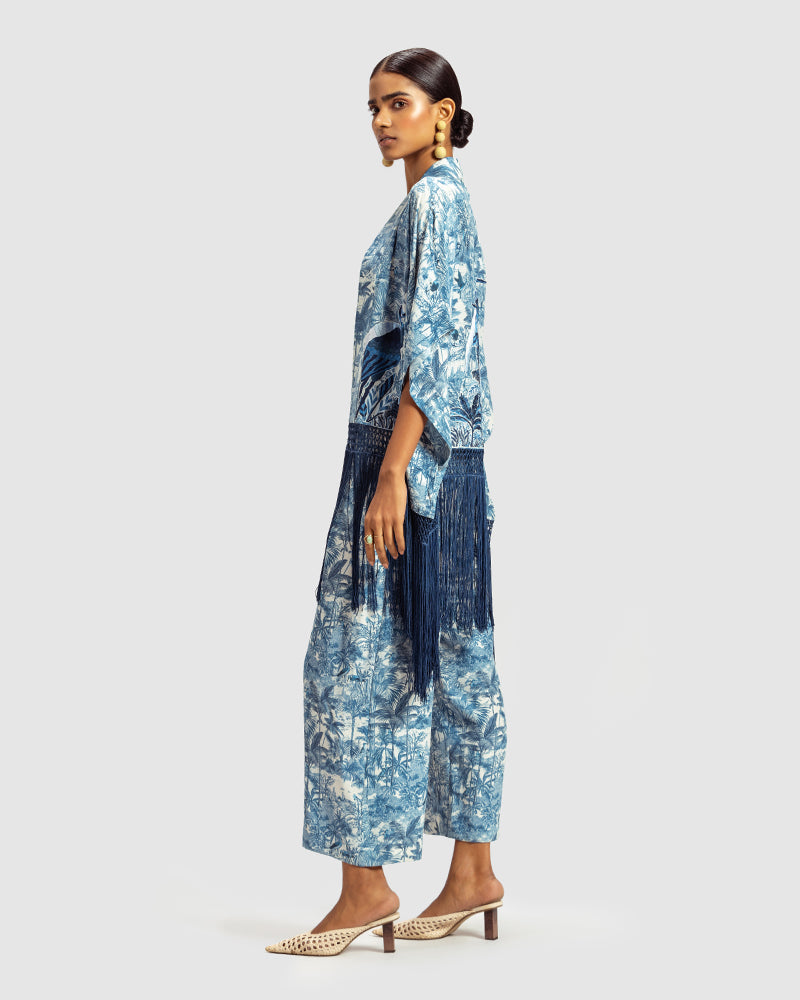 Blue Gara Embroidered Tropical Print ShrugProduct DescriptionMade from silk satin, this statement shrug is enveloped in a blend of tropical print and tonal Gara embroidery. Also features a generous silk frinShrugsBlue Gara Embroidered Tropical Print Shrug