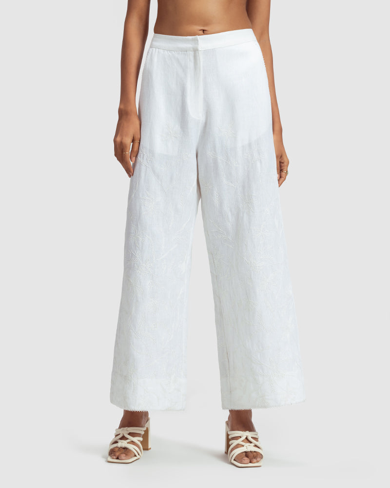 White Linen Palazzo Pant With Dori EmbroideryProduct DescriptionOur flared linen palazzo includes Dori embroidery all over and a delicate touch of lace at the hem. It also features a hook-and-eye zipper closurePantsWhite Linen Palazzo Pant
