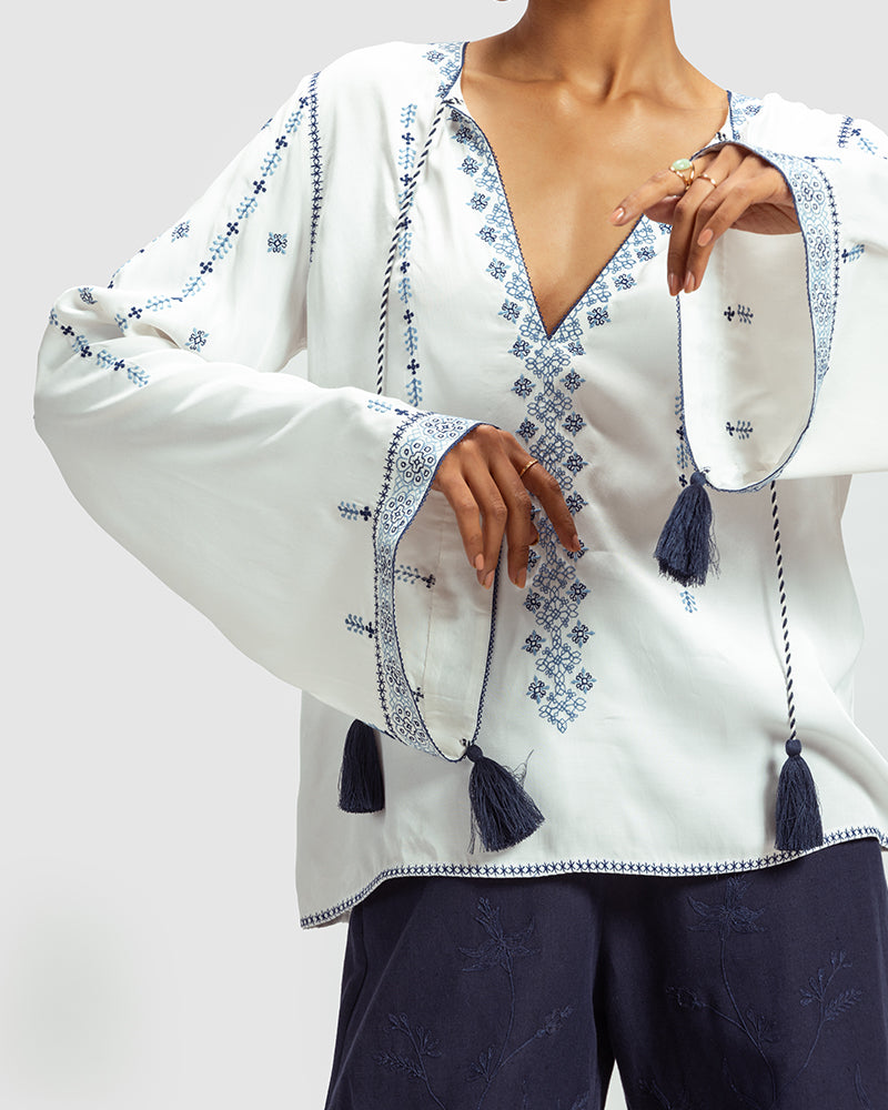 Blue on White Embroidered Satin Blend TopProduct DescriptionThis relaxed-fit top is adorned with Kolam-inspired motif embroidery, and also features tassels on the front-neck drawstring and sleeve hems.
FroWhite Embroidered Satin Blend Top