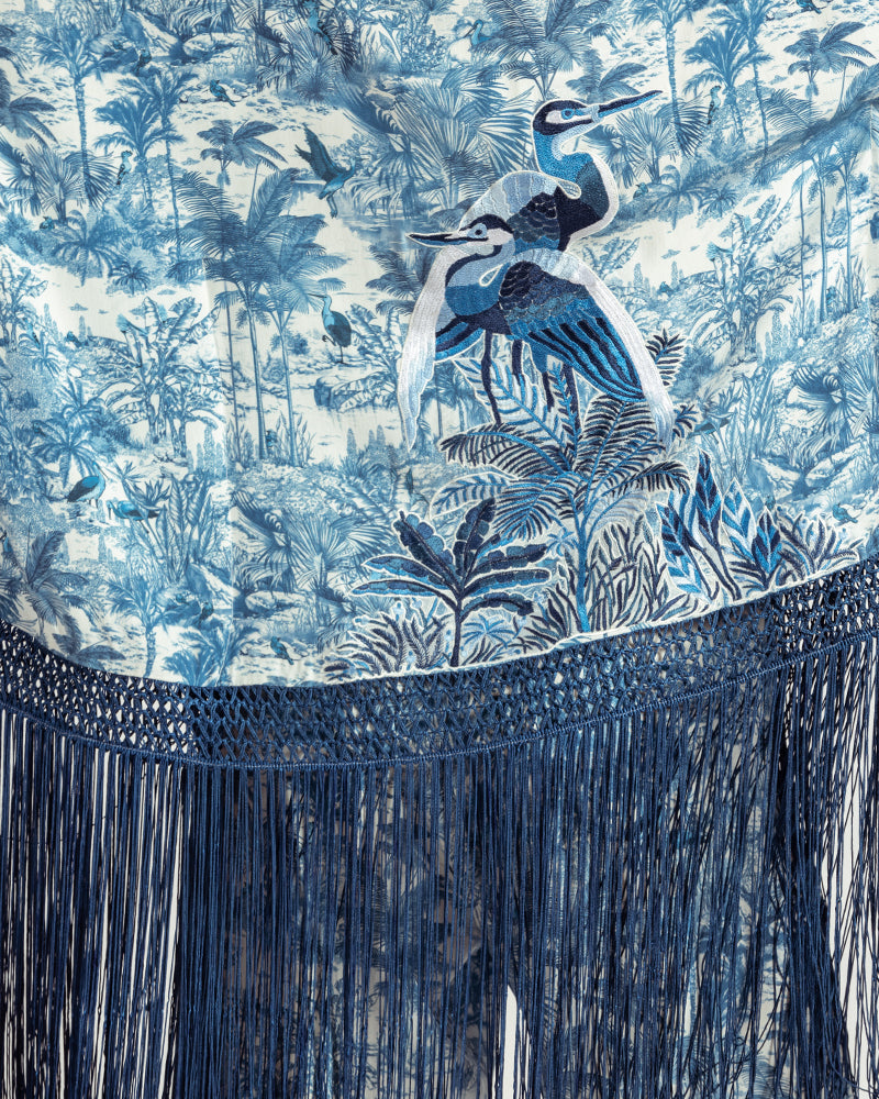 Blue Gara Embroidered Tropical Print ShrugProduct DescriptionMade from silk satin, this statement shrug is enveloped in a blend of tropical print and tonal Gara embroidery. Also features a generous silk frinShrugsBlue Gara Embroidered Tropical Print Shrug