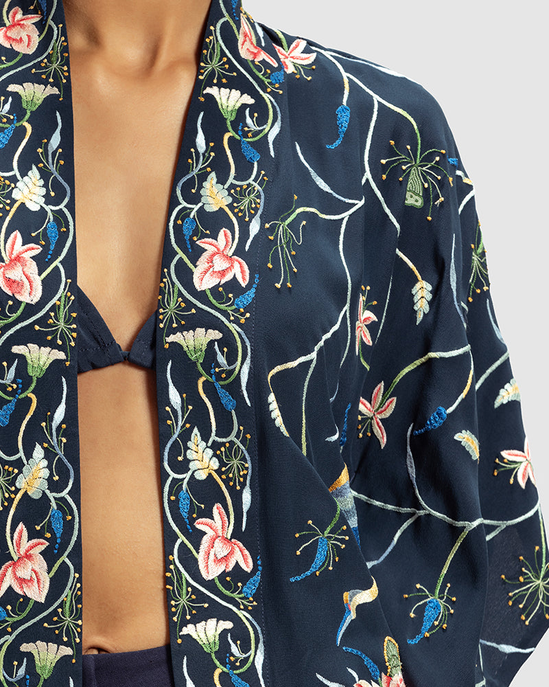 Navy Parsi Gara Embroidered ShrugProduct DescriptionTraditionally seen on Parsi saris, this luxurious silk crepe shrug is adorned with multicoloured Parsi Gara hand embroidery. It also features a geShrugsNavy Parsi Gara Embroidered Shrug