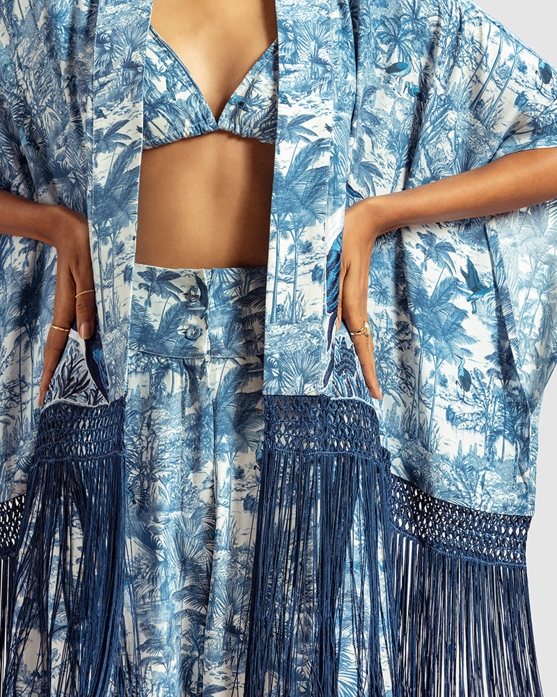 Blue Gara Embroidered Tropical Print ShrugProduct DescriptionMade from silk satin, this statement shrug is enveloped in a blend of tropical print and tonal Gara embroidery. Also features a generous silk frinShrugsBlue Gara Embroidered Tropical Print Shrug