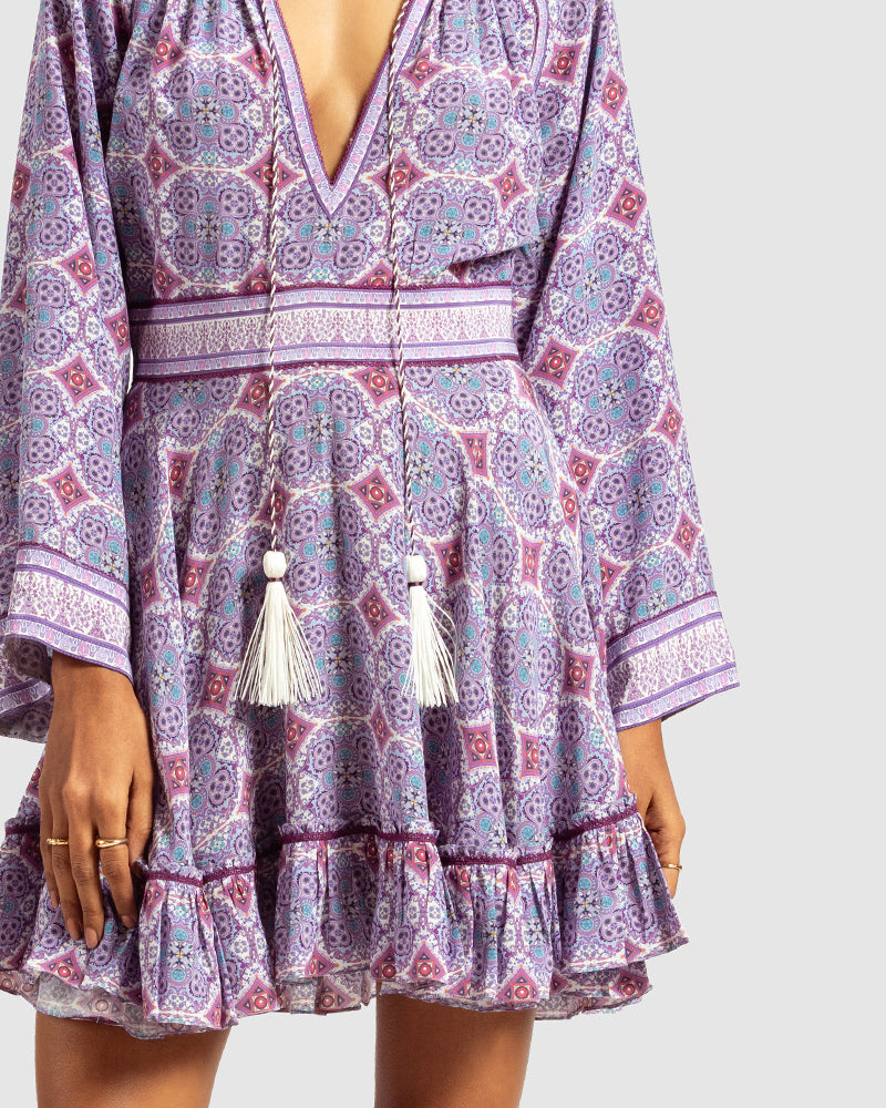 Lavender Marissa Print Ruffled Silk DressProduct DescriptionThis print patchwork ruffled dress is a mix of fit and flare, making it a perfect summer dress. It features a V-shaped neckline, a tasselled drawsDressesLavender Marissa Print Ruffled Silk Dress