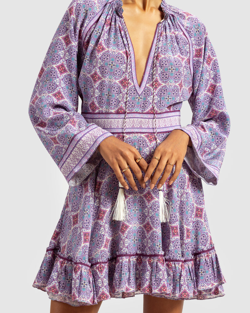 Lavender Marissa Print Ruffled Silk DressProduct DescriptionThis print patchwork ruffled dress is a mix of fit and flare, making it a perfect summer dress. It features a V-shaped neckline, a tasselled drawsDressesLavender Marissa Print Ruffled Silk Dress