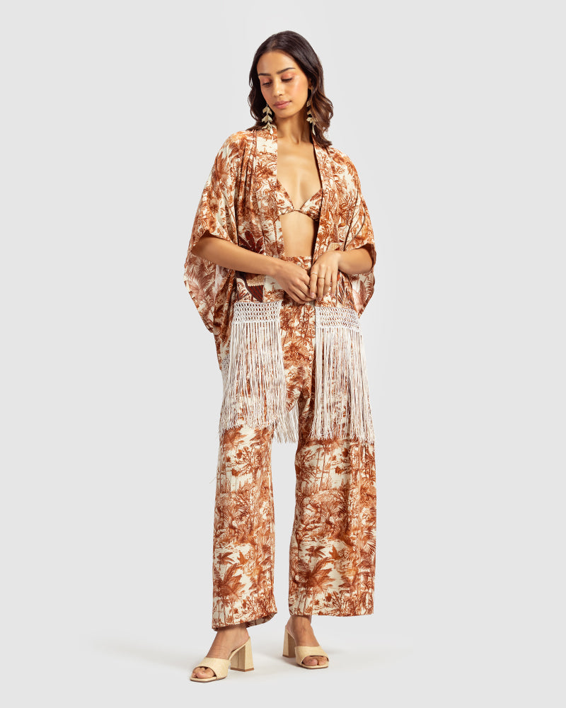 Brown Gara Embroidered Tropical Print ShrugProduct DescriptionMade from silk satin, this statement shrug is enveloped in a blend of tropical print and tonal Gara embroidery. Also features a generous silk frinShrugsBrown Gara Embroidered Tropical Print Shrug