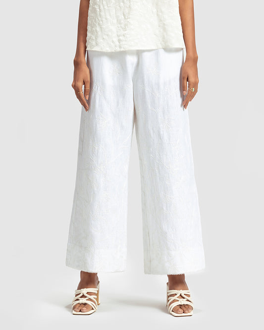 White Linen Palazzo Pant With Dori EmbroideryProduct DescriptionOur flared linen palazzo includes Dori embroidery all over and a delicate touch of lace at the hem. It also features a hook-and-eye zipper closurePantsWhite Linen Palazzo Pant