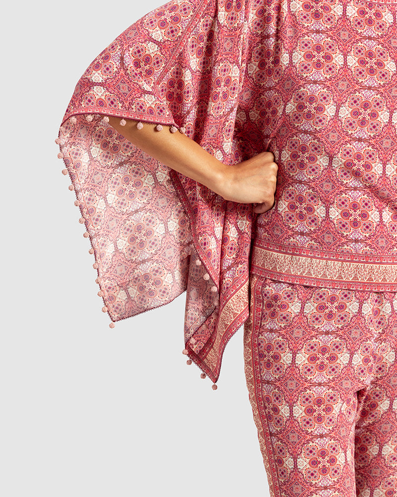 Pink Marissa Print Silk Poncho TopProduct DescriptionMade from silk crepe, this boatneck poncho top features our modern geometric print patchwork. Comes in a relaxed fit and also features bobble trimTopsPink Marissa Print Silk Poncho Top