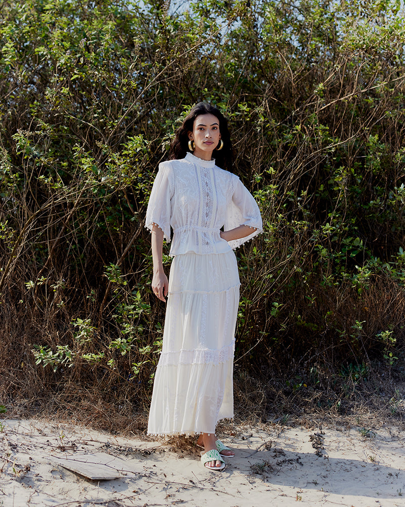 Chikankari Tiered SkirtProduct DescriptionOur tiered skirt features intricate hand chikankari embroidery with delicate jaali work and embossed white-thread stitching. The garment also inclSkirtsChikankari Tiered Skirt