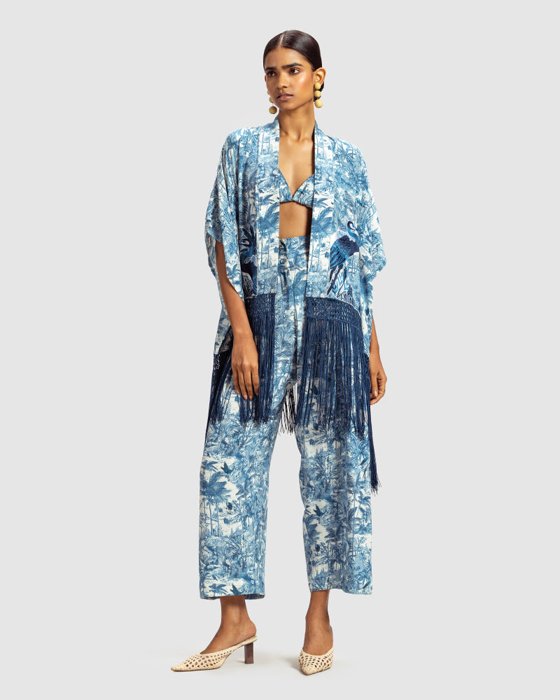 Blue Gara Embroidered Tropical Print ShrugProduct DescriptionMade from silk satin, this statement shrug is enveloped in a blend of tropical print and tonal Gara embroidery. Also features a generous silk frinShrugsBlue Gara Embroidered Tropical Print Shrug