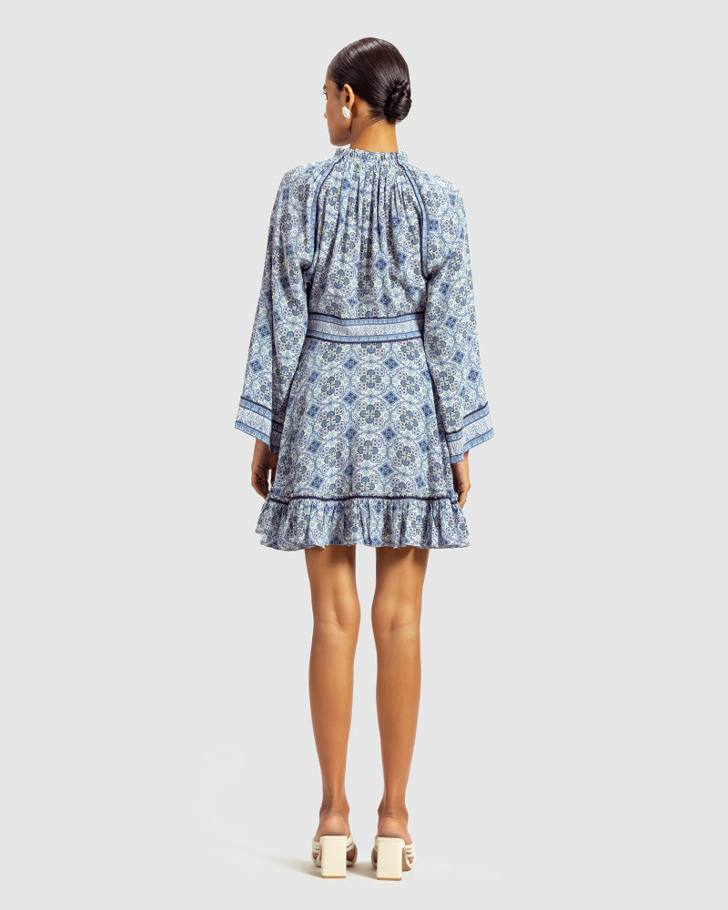 Blue Marissa Print Ruffled Silk DressProduct DescriptionThis print patchwork ruffled dress is a mix of fit and flare, making it a perfect summer dress. It features a V-shaped neckline, a tasselled drawsDressesBlue Marissa Print Ruffled Silk Dress