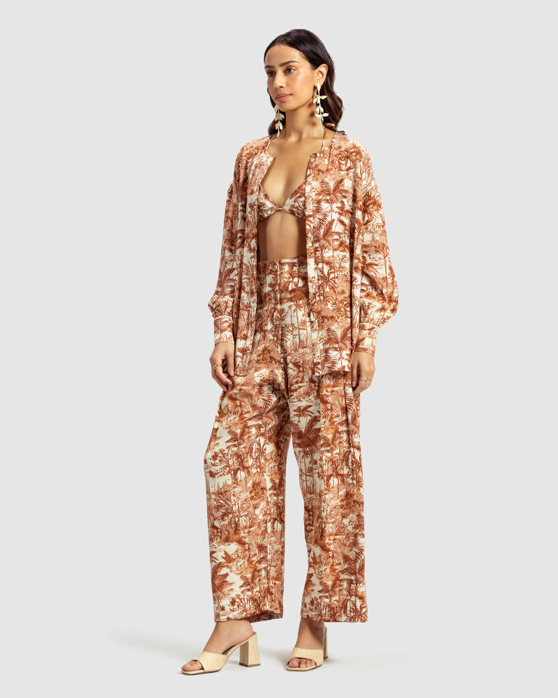 Brown Tropical Print Silk Pleated PantProduct DescriptionMade from silk satin, these high-waisted pleated pants feature our statement tropical print that reimagines Indian flora and fauna motifs with conPantsBrown Tropical Print Silk Pleated Pant