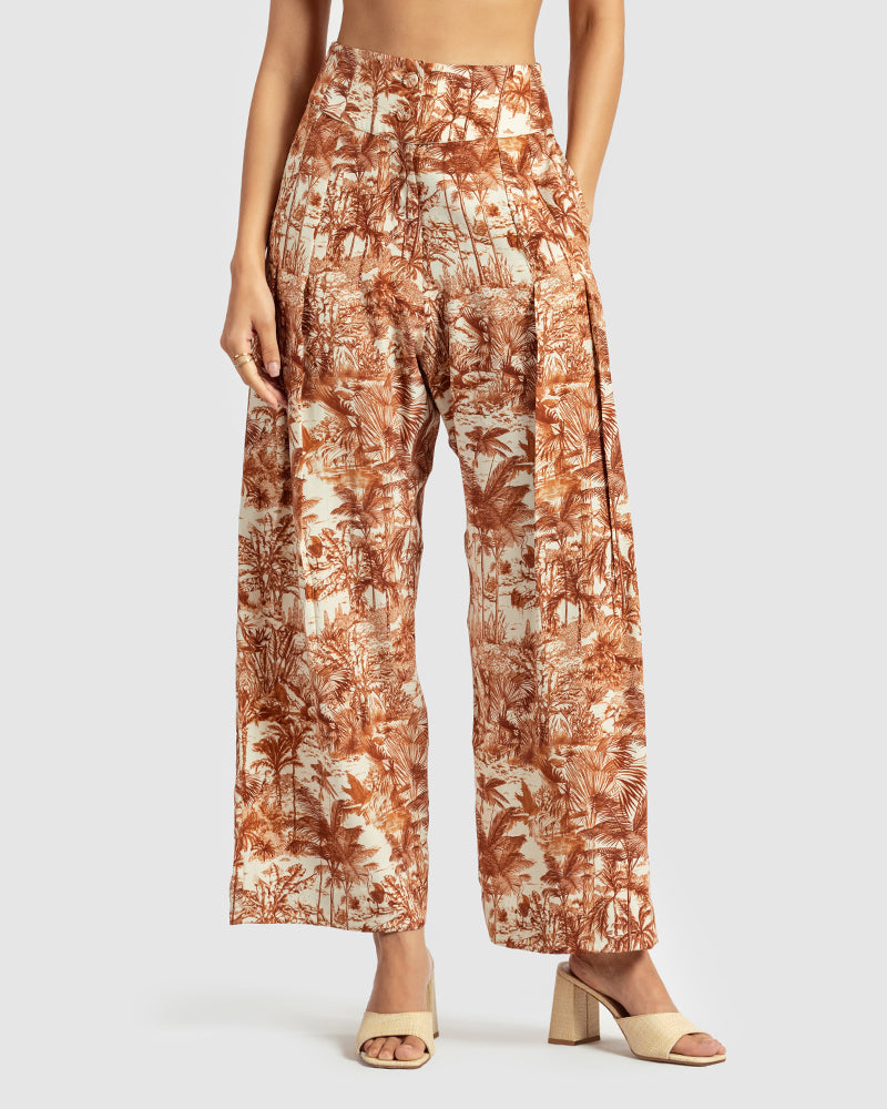 Brown Tropical Print Silk Pleated PantProduct DescriptionMade from silk satin, these high-waisted pleated pants feature our statement tropical print that reimagines Indian flora and fauna motifs with conPantsBrown Tropical Print Silk Pleated Pant