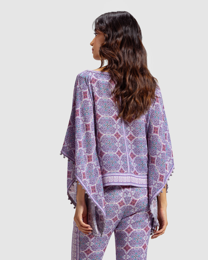 Lavender Marissa Print Silk Poncho TopProduct DescriptionMade from silk crepe, this boatneck poncho top features our modern geometric print patchwork. Comes in a relaxed fit and also features bobble trimTopsLavender Marissa Print Silk Poncho Top