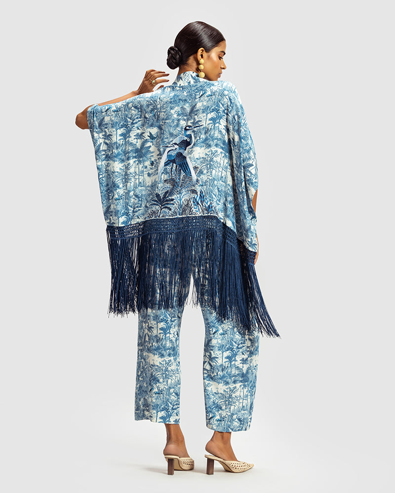 Blue Gara Embroidered Tropical Print ShrugProduct DescriptionMade from silk satin, this statement shrug is enveloped in a blend of tropical print and tonal Gara embroidery. Also features a generous silk frinShrugsBlue Gara Embroidered Tropical Print Shrug