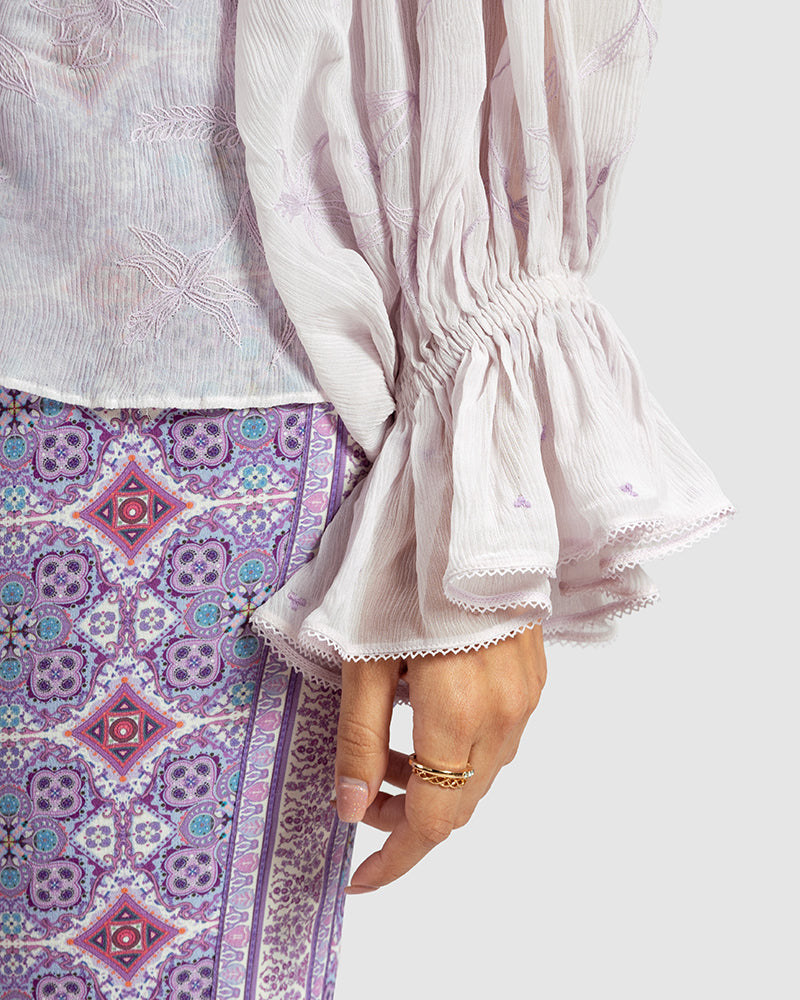 Lilac Ruffled Silk Blouse With Dori EmbroideryProduct DescriptionThis statement crinkled silk chiffon blouse features Dori embroidery and floral motifs inspired by Mughal architecture. Details include elasticateTopsLilac Ruffled Silk Blouse