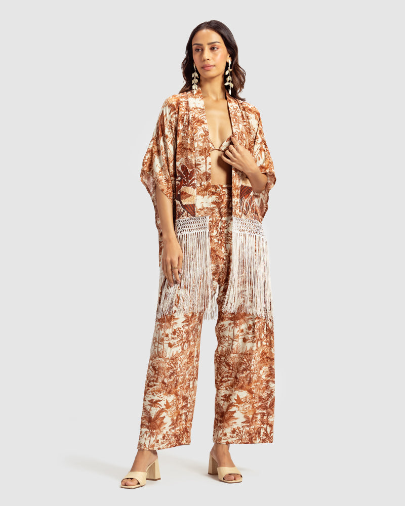 Brown Gara Embroidered Tropical Print ShrugProduct DescriptionMade from silk satin, this statement shrug is enveloped in a blend of tropical print and tonal Gara embroidery. Also features a generous silk frinShrugsBrown Gara Embroidered Tropical Print Shrug